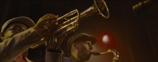 Wide shot frame from La La Land — hat, hand, suit