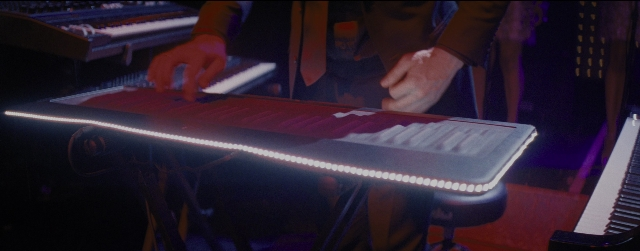 Wide shot frame from La La Land — room, piano, person