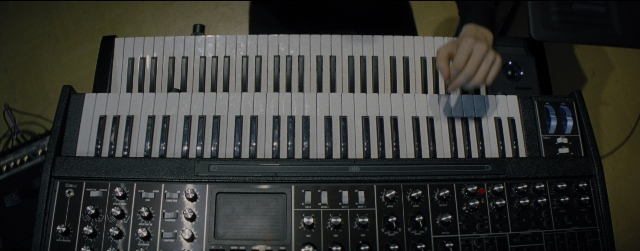 Wide shot frame from La La Land — hand, person, musical keyboard