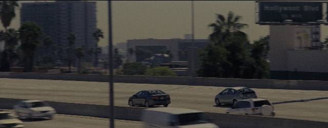 Wide shot frame from La La Land — street, car, truck