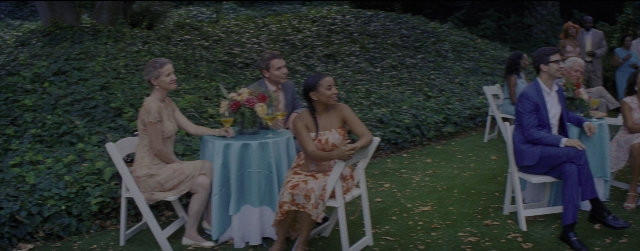 Wide shot frame from La La Land — sitting, standing, table
