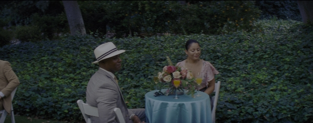 Wide shot frame from La La Land — sitting, table, dialogue