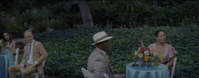 Wide shot frame from La La Land — sitting, table, dialogue