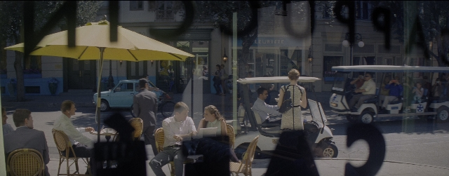 Wide shot frame from La La Land — sitting, dialogue, street