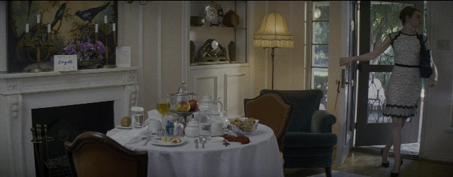 Wide shot frame from La La Land — standing, room, table