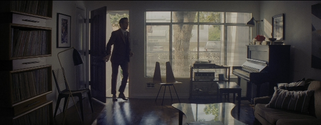 Wide shot frame from La La Land — standing, table, door