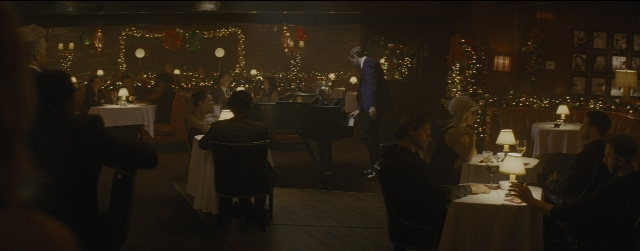 Wide shot frame from La La Land — sitting, standing, room