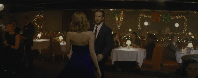 Wide shot frame from La La Land — sitting, walking, room