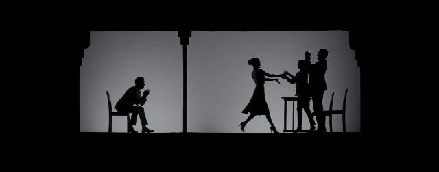 Wide shot frame from La La Land — sitting, standing, room