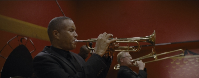 Frame from La La Land — room, suit, trumpet