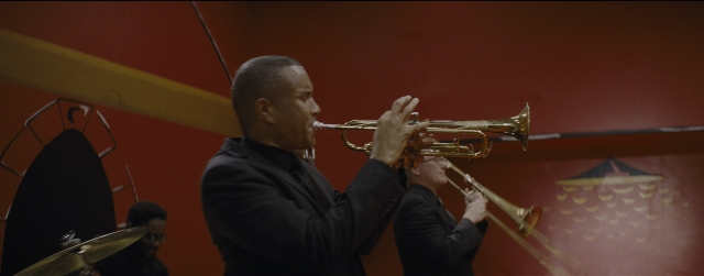 Wide shot frame from La La Land — room, suit, trumpet