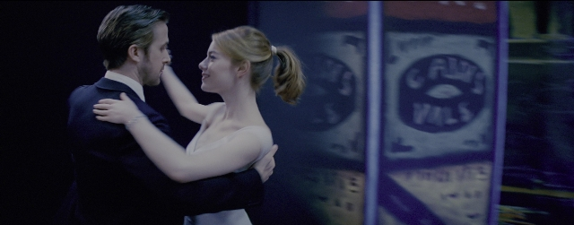 Wide shot frame from La La Land — room, suit, dress