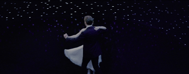 Wide shot frame from La La Land — room, suit, night