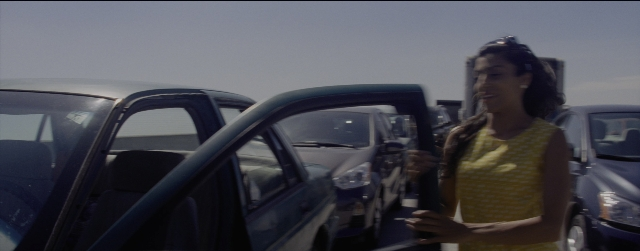 Wide shot frame from La La Land — standing, door, car
