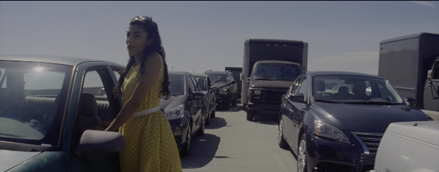 Wide shot frame from La La Land — standing, car, dress