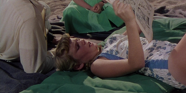 Frame from Magnificent Obsession — sitting, suit, dress