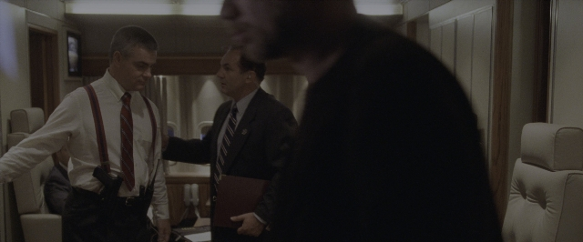 Wide shot frame from Air Force One — standing, room, dialogue