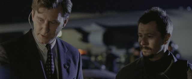 Medium shot frame from Air Force One — standing, room, dialogue