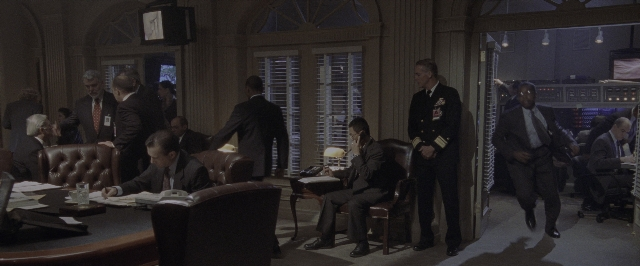 Wide shot frame from Air Force One — sitting, standing, room