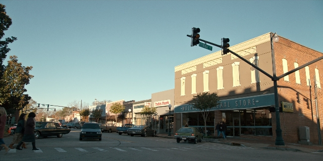 Wide shot frame from Stranger Things — walking, street, car