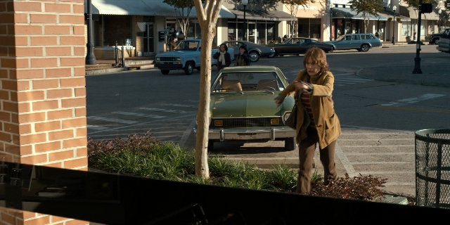 Wide shot frame from Stranger Things — standing, walking, street