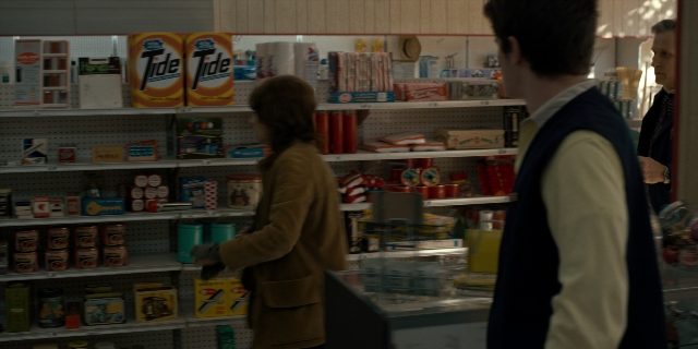 Wide shot frame from Stranger Things — standing, coat, food