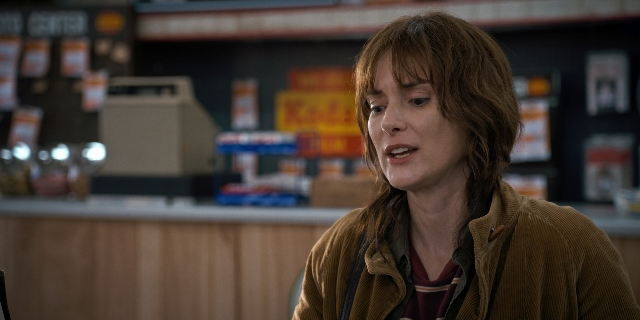 Wide shot frame from Stranger Things — sitting, restaurant, face