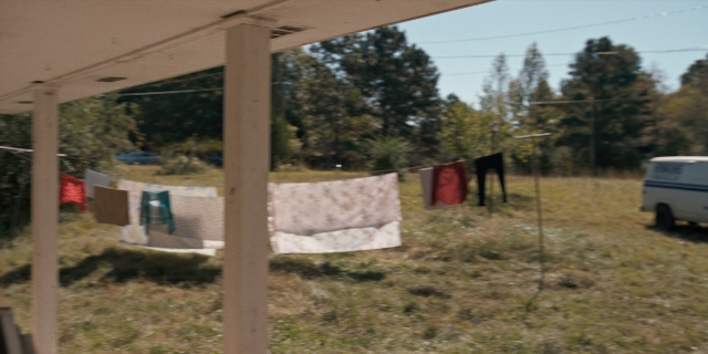 Wide shot frame from Stranger Things — street, van, wheel