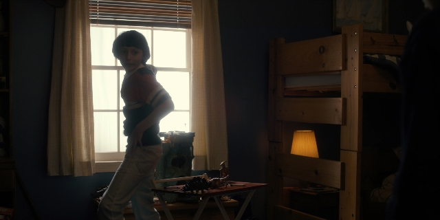 Wide shot frame from Stranger Things — standing, room, table