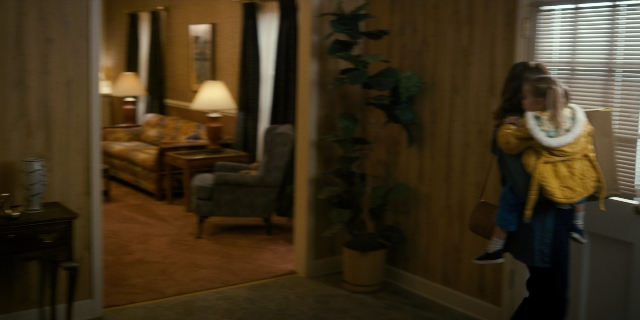 Wide shot frame from Stranger Things — standing, room, table