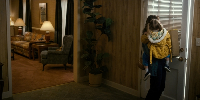 Wide shot frame from Stranger Things — standing, room, table