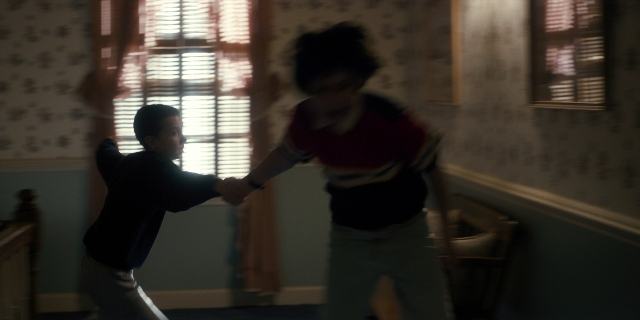 Wide shot frame from Stranger Things — room, shirt, person