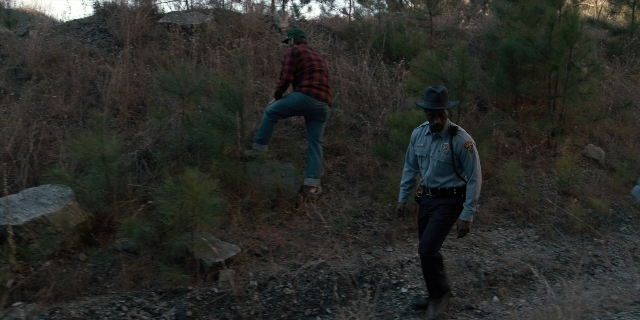 Wide shot frame from Stranger Things — walking, hat, shirt
