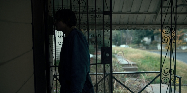 Wide shot frame from Stranger Things — standing, street, house