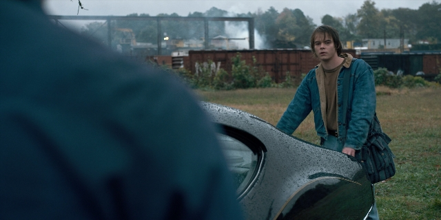 Wide shot frame from Stranger Things — standing, car, jacket