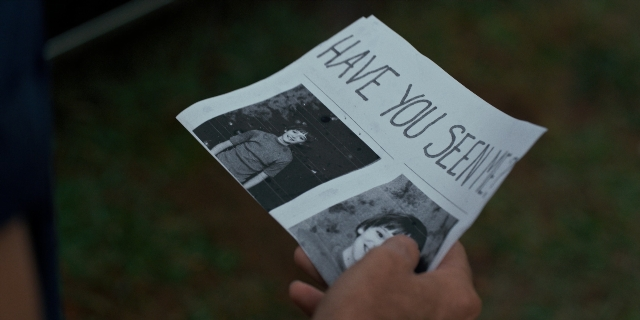 Frame from Stranger Things — hand, newspaper, person