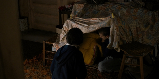 Wide shot frame from Stranger Things — sitting, room, bed