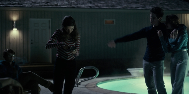 Wide shot frame from Stranger Things — sitting, standing, room