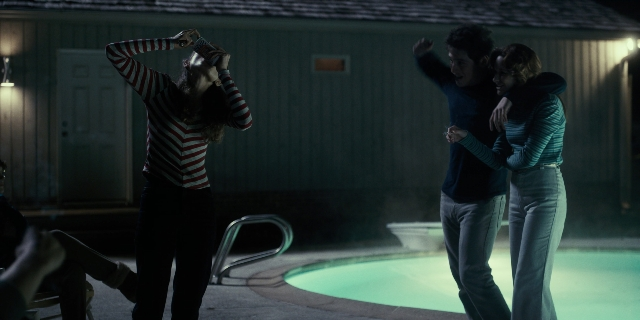 Wide shot frame from Stranger Things — standing, hand, night