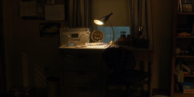Wide shot frame from Stranger Things — desk, book, room