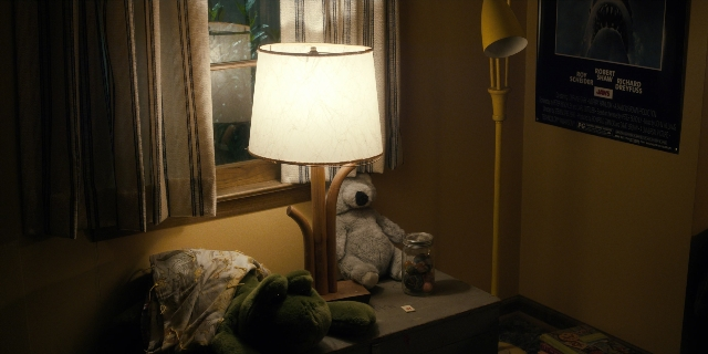 Wide shot frame from Stranger Things — book, room, night