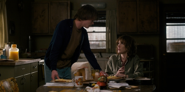 Wide shot frame from Stranger Things — sitting, standing, plate