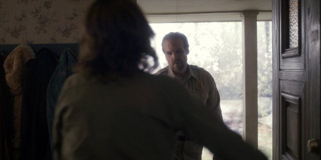 Wide shot frame from Stranger Things — standing, room, door
