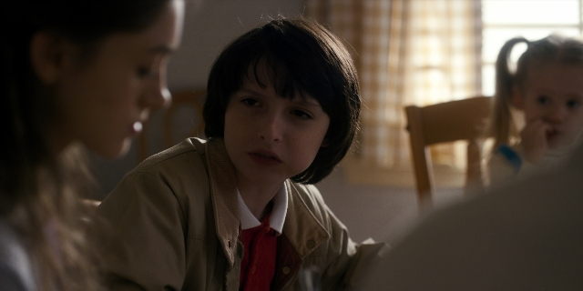 Medium shot frame from Stranger Things — sitting, standing, room
