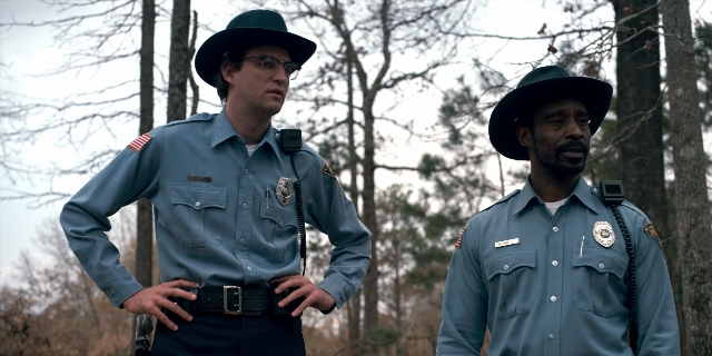Wide shot frame from Stranger Things — standing, hat, uniform