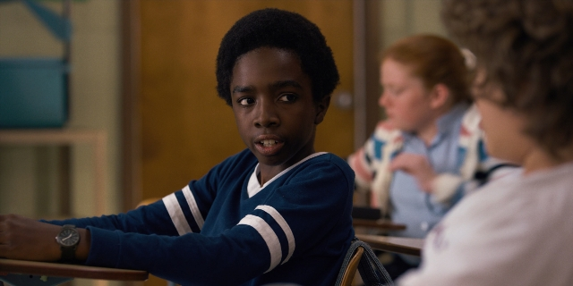 Medium shot frame from Stranger Things — sitting, standing, face