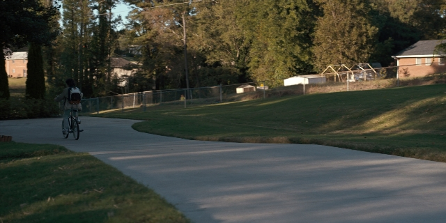 Wide shot frame from Stranger Things — bicycle, person