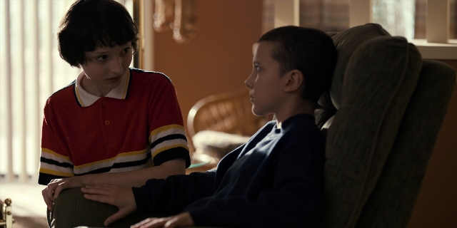 Wide shot frame from Stranger Things — sitting, room, dialogue