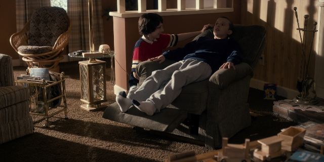 Wide shot frame from Stranger Things — sitting, standing, room