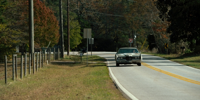 Wide shot frame from Stranger Things — street, car, wheel